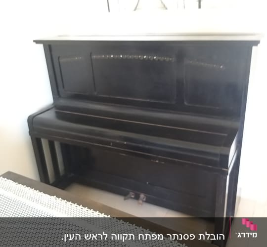 פסנתר עומד כהה עם גלגלים קטנים בתחתית